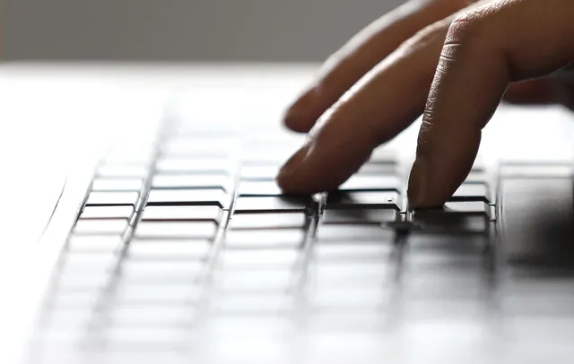 A person types an SEO-optimized blog on their laptop computer