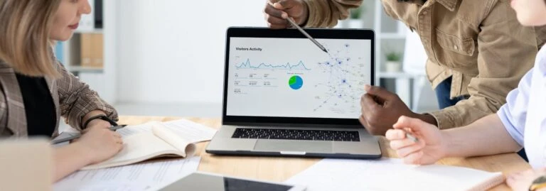 a team member points to visitor activity on a marketing report