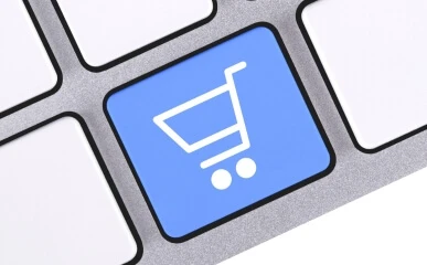 An e commerce shopping cart button showing as a blue button a keyboard
